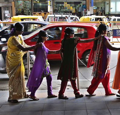 Blind womens walking with the help of each other near road